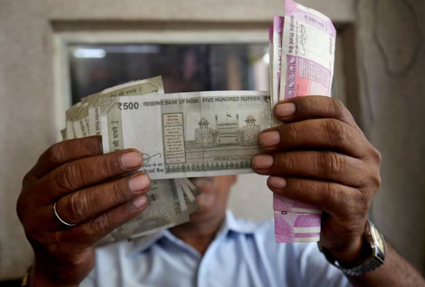 A cashier checks Indian rupee notes inside a room at a fuel station in Mumbai